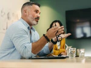 Mature,Businessman,Having,A,Discussion,With,His,Colleagues,In,A