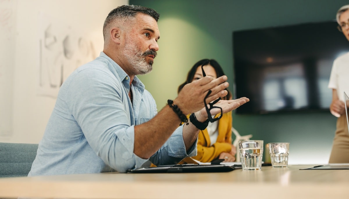 Mature,Businessman,Having,A,Discussion,With,His,Colleagues,In,A