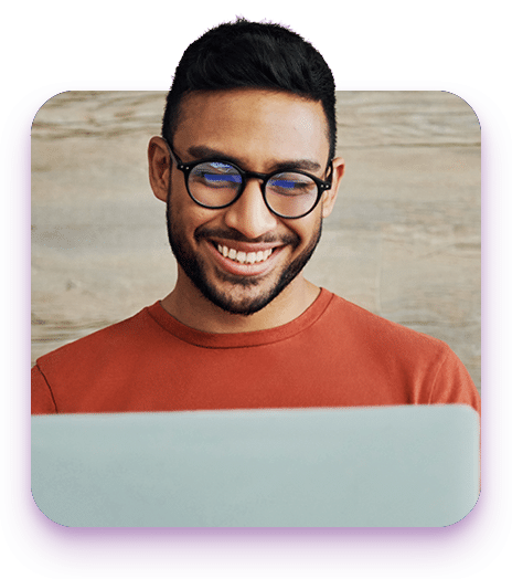 Shot of a handsome young man sitting alone in his living room and using his laptop